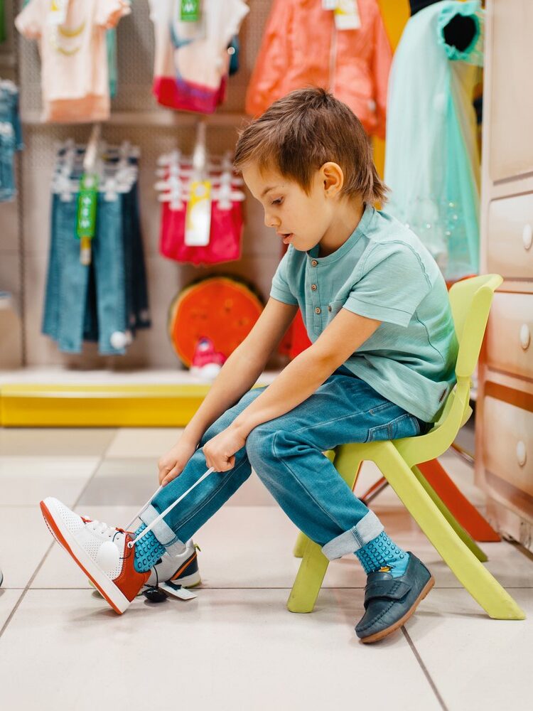 a boy tries on sneakers in a store